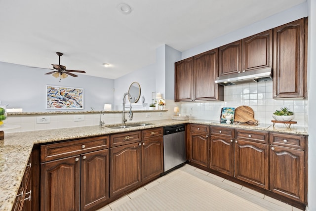 kitchen with light stone counters, black electric cooktop, stainless steel dishwasher, under cabinet range hood, and a sink