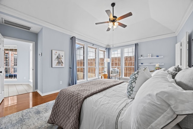 bedroom with crown molding, visible vents, ceiling fan, light wood-type flooring, and baseboards