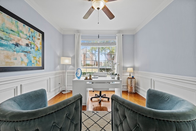 office area with ceiling fan, wainscoting, ornamental molding, and light wood-type flooring