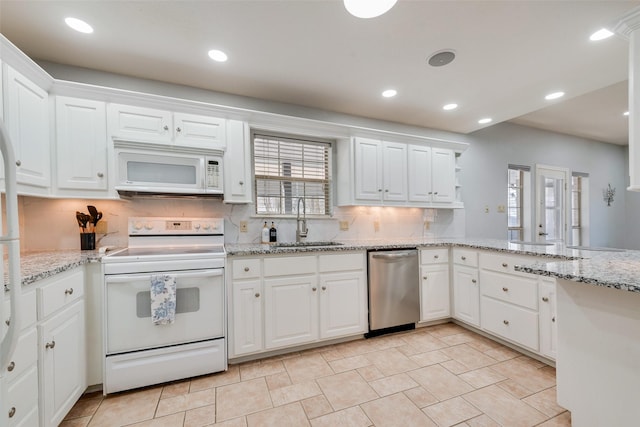 kitchen with white cabinetry, light stone countertops, sink, white appliances, and decorative backsplash