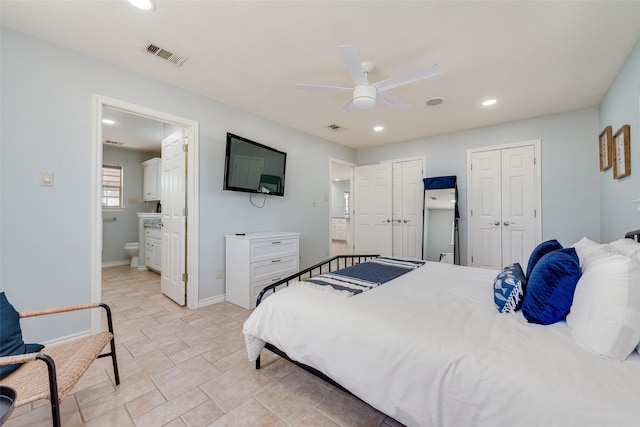 bedroom with ensuite bathroom, ceiling fan, and two closets