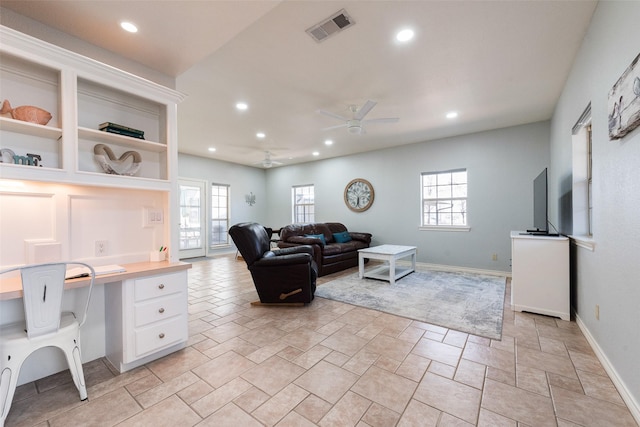 living room with ceiling fan, plenty of natural light, and built in desk