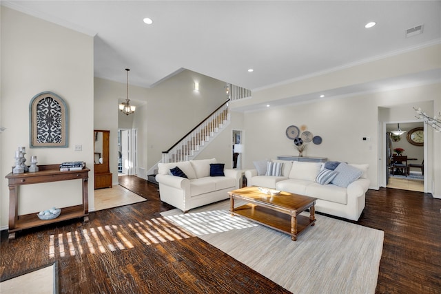 living room featuring hardwood / wood-style flooring, stairway, crown molding, a chandelier, and recessed lighting