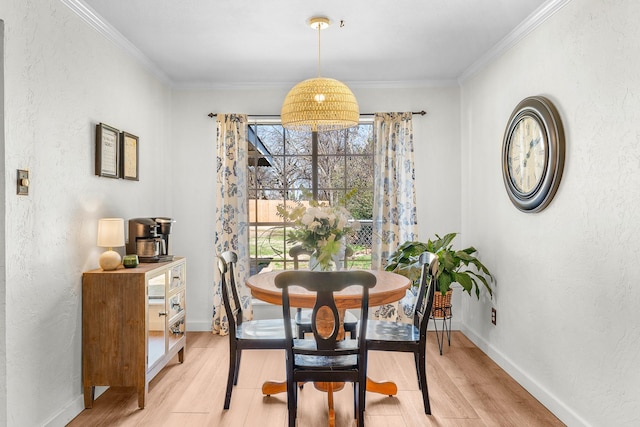 dining space featuring ornamental molding and light hardwood / wood-style floors