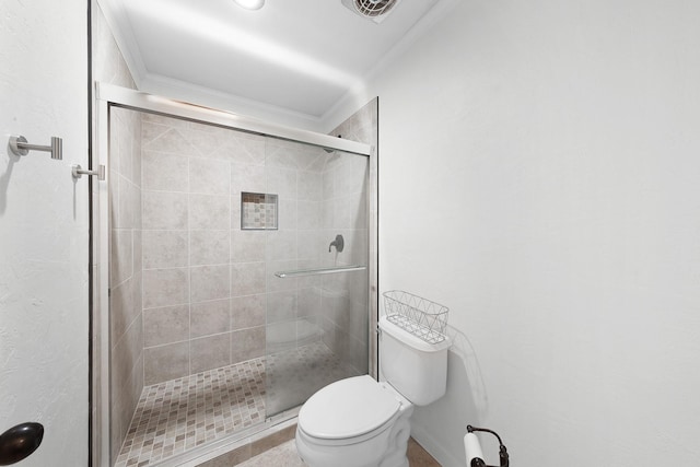 bathroom featuring ornamental molding, a shower with shower door, and toilet