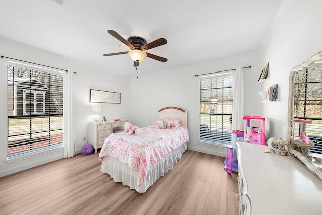 bedroom with ceiling fan, ornamental molding, and light hardwood / wood-style floors