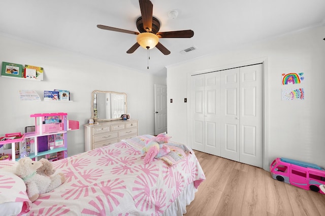 bedroom with ceiling fan, light hardwood / wood-style flooring, ornamental molding, and a closet