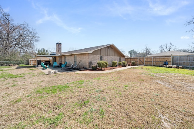 rear view of house with a patio area and a lawn