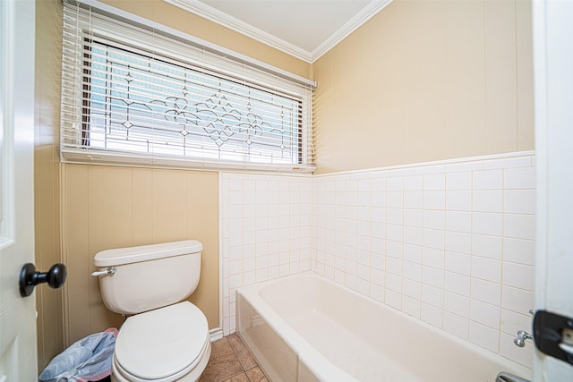 bathroom with tile patterned floors, crown molding, a tub to relax in, and toilet