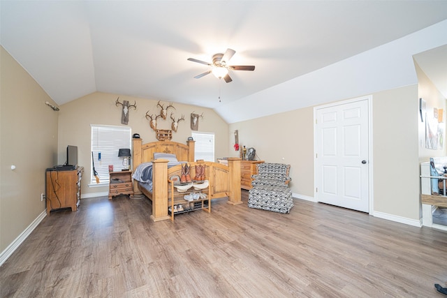 bedroom with ceiling fan, vaulted ceiling, and hardwood / wood-style floors