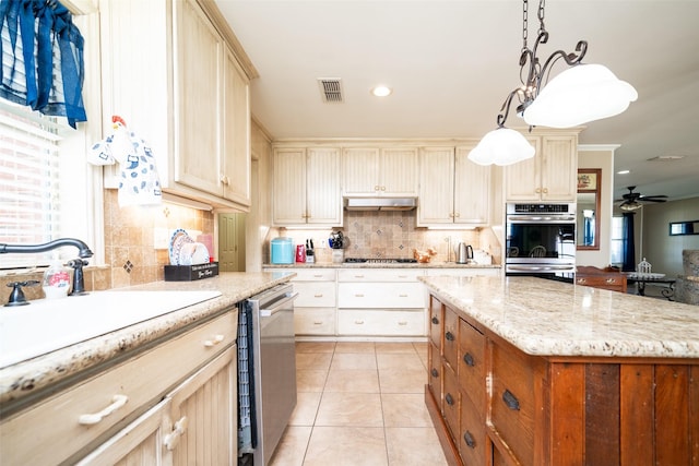 kitchen with hanging light fixtures, backsplash, ceiling fan, light tile patterned floors, and appliances with stainless steel finishes