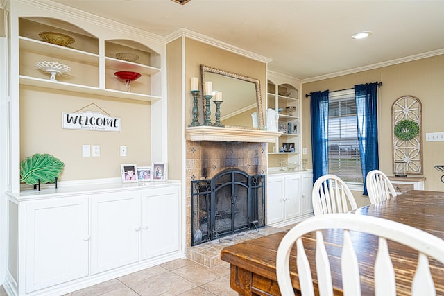 dining space with a brick fireplace, light tile patterned floors, crown molding, and built in shelves