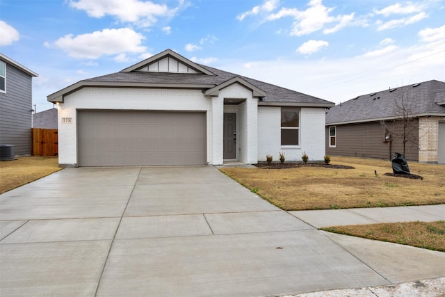 ranch-style home with a shingled roof, concrete driveway, an attached garage, a front lawn, and brick siding