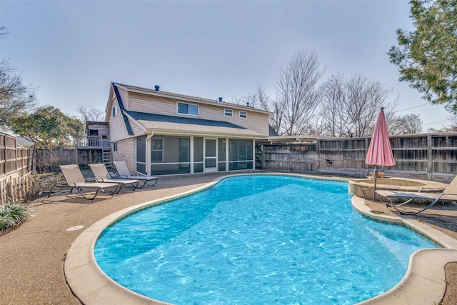 view of pool with a sunroom and a patio area