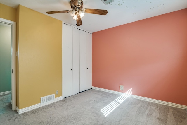 unfurnished bedroom featuring ceiling fan, light carpet, and a closet