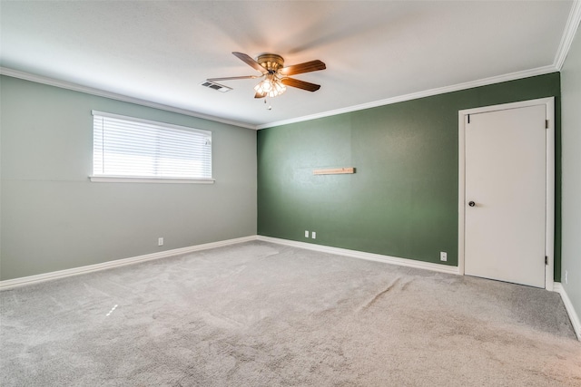 carpeted empty room featuring ceiling fan and crown molding