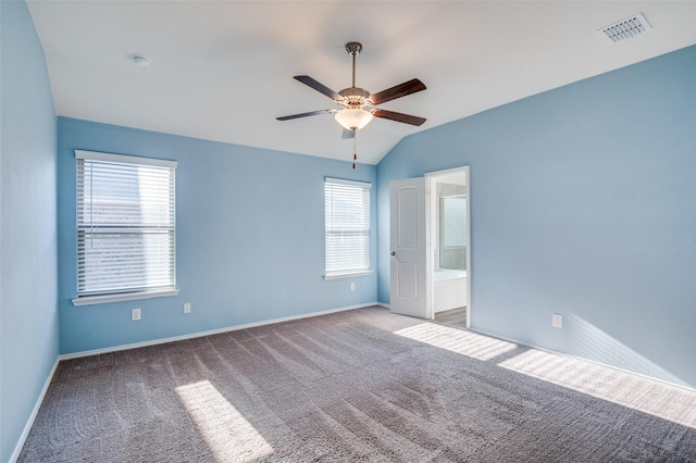 spare room featuring light carpet, baseboards, visible vents, a ceiling fan, and vaulted ceiling