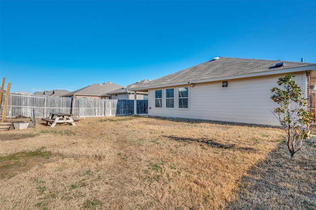 back of house featuring a lawn and fence