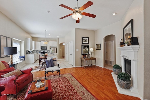 living room featuring ceiling fan and light hardwood / wood-style flooring