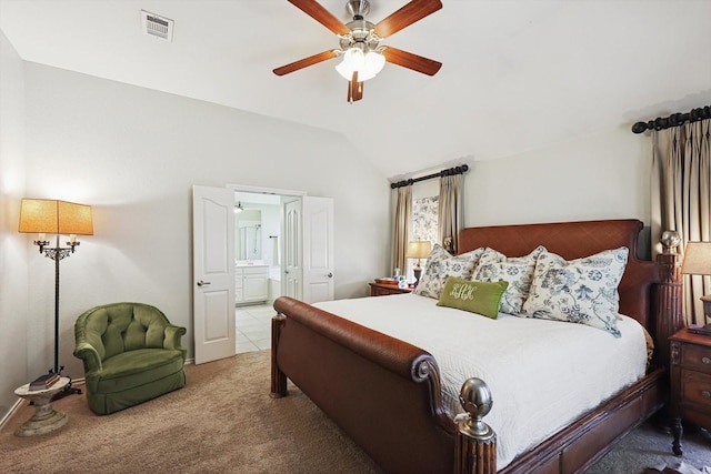 carpeted bedroom with ensuite bathroom, vaulted ceiling, and ceiling fan