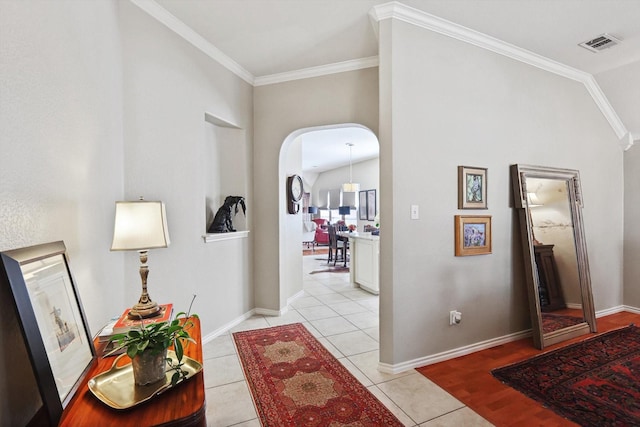 hall with light tile patterned flooring and ornamental molding