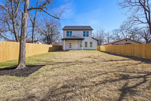 back of house with a lawn and a fenced backyard