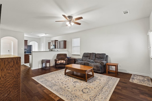 living room with ceiling fan and dark hardwood / wood-style floors