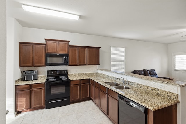 kitchen with sink, kitchen peninsula, tasteful backsplash, and black appliances