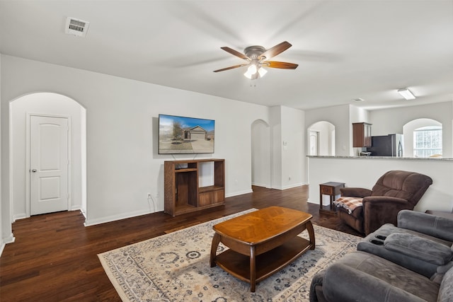 living room with dark hardwood / wood-style flooring and ceiling fan