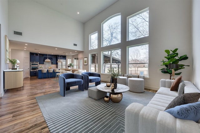 living area with plenty of natural light, visible vents, and wood finished floors