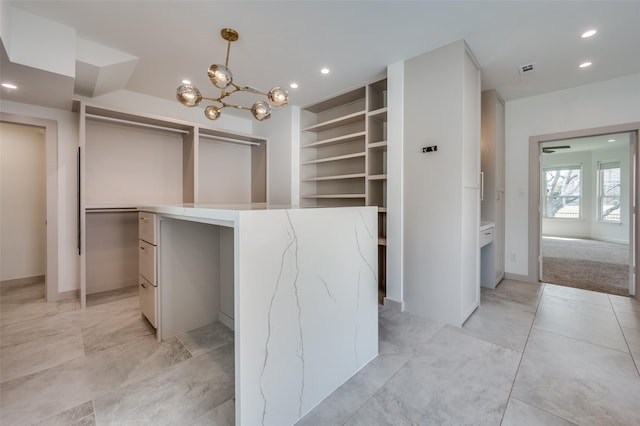 interior space with modern cabinets, a kitchen island, hanging light fixtures, light countertops, and recessed lighting