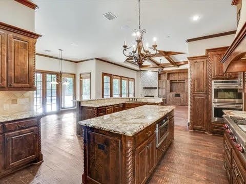 kitchen featuring a center island, hanging light fixtures, stainless steel double oven, and an inviting chandelier