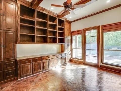 unfurnished office featuring crown molding, plenty of natural light, and ceiling fan