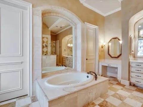 bathroom featuring crown molding and a bath