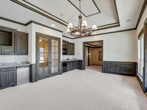 unfurnished dining area with french doors, light carpet, and crown molding