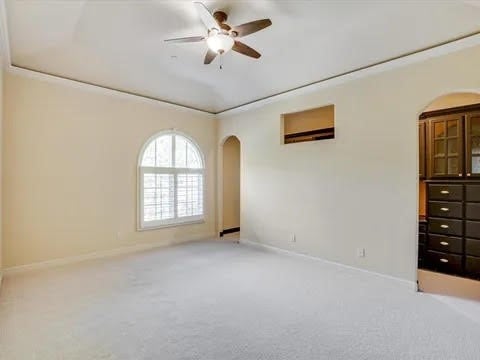 empty room featuring ceiling fan, carpet, and baseboards