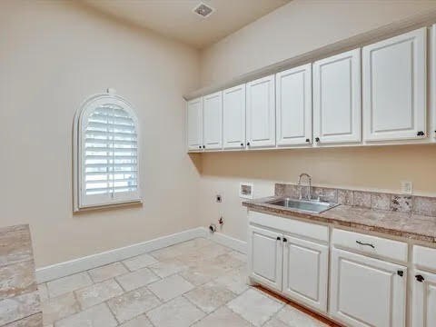 laundry room with hookup for a washing machine, hookup for an electric dryer, a sink, baseboards, and cabinet space