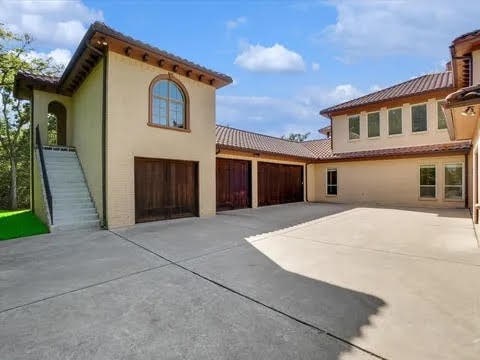 exterior space featuring a tiled roof, concrete driveway, and stucco siding