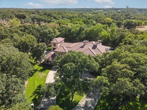 bird's eye view with a wooded view