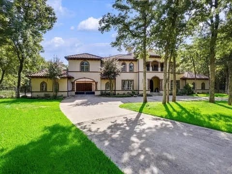 mediterranean / spanish home featuring driveway, a front yard, and stucco siding