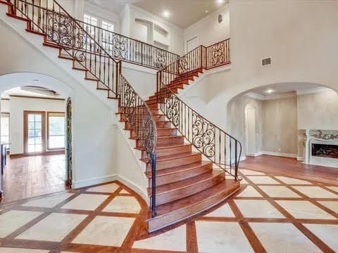 stairway featuring baseboards, arched walkways, and recessed lighting