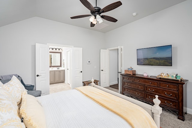 carpeted bedroom with ceiling fan, ensuite bath, and lofted ceiling