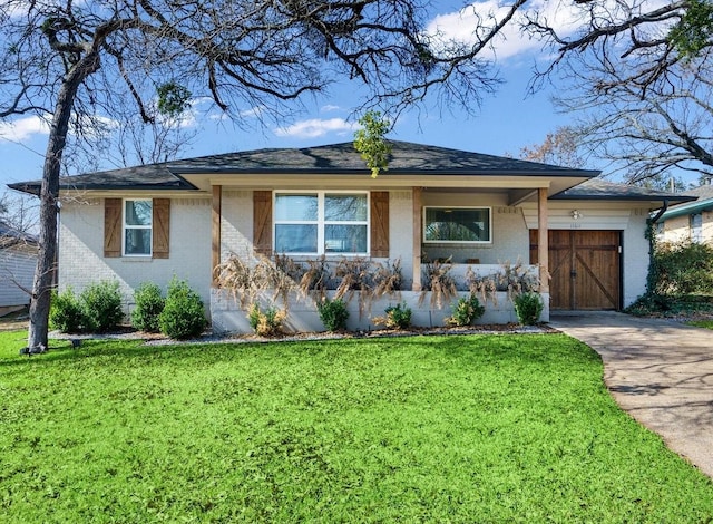 ranch-style home featuring concrete driveway, a front lawn, an attached garage, and brick siding