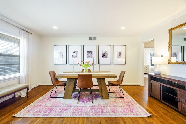 dining area with baseboards, crown molding, visible vents, and wood finished floors