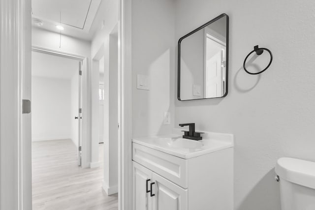 bathroom featuring toilet, vanity, and hardwood / wood-style floors