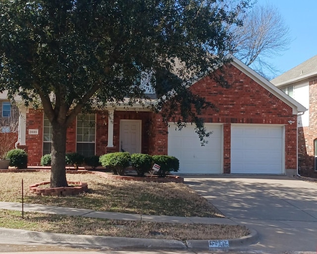 view of front of property with concrete driveway, brick siding, and an attached garage