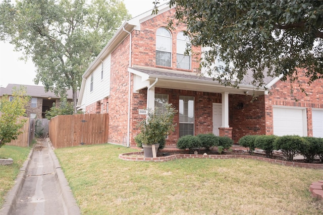 view of front facade featuring an attached garage, fence, a front lawn, and brick siding