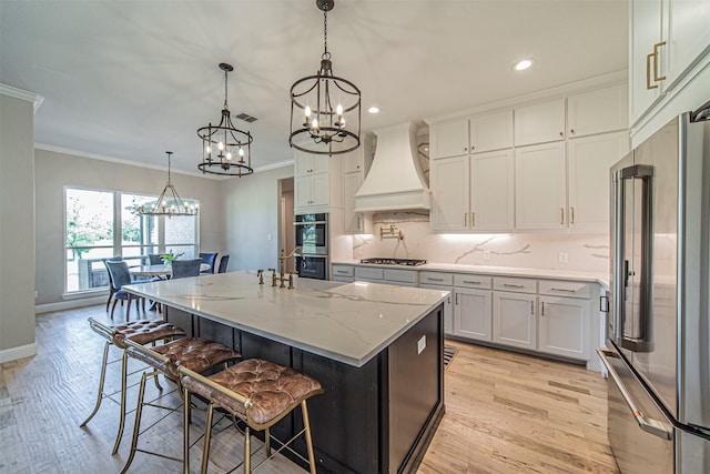 kitchen with a breakfast bar, premium range hood, pendant lighting, stainless steel appliances, and a kitchen island with sink