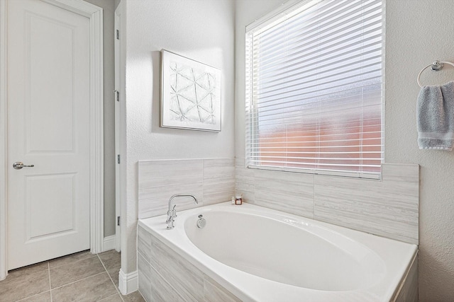 bathroom with tile patterned flooring and a relaxing tiled tub