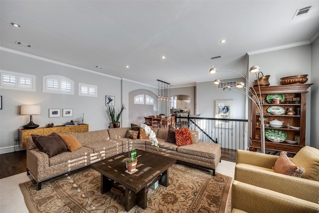 living room featuring ornamental molding, hardwood / wood-style flooring, and a notable chandelier